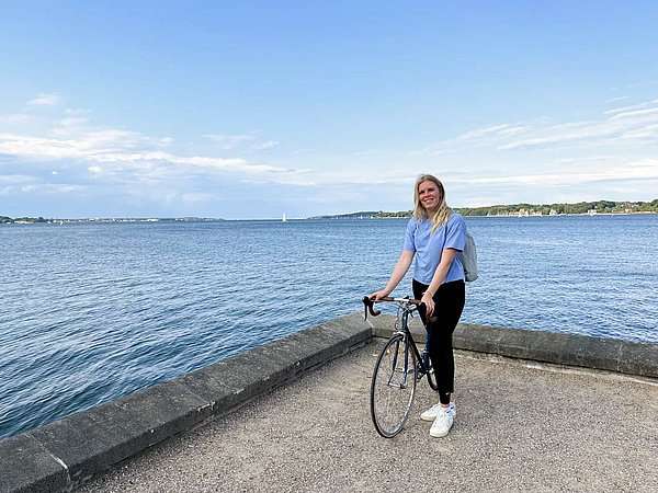 Sarah Westermann mit ihrem Fahrrad am Wasser. Foto: DLRG 